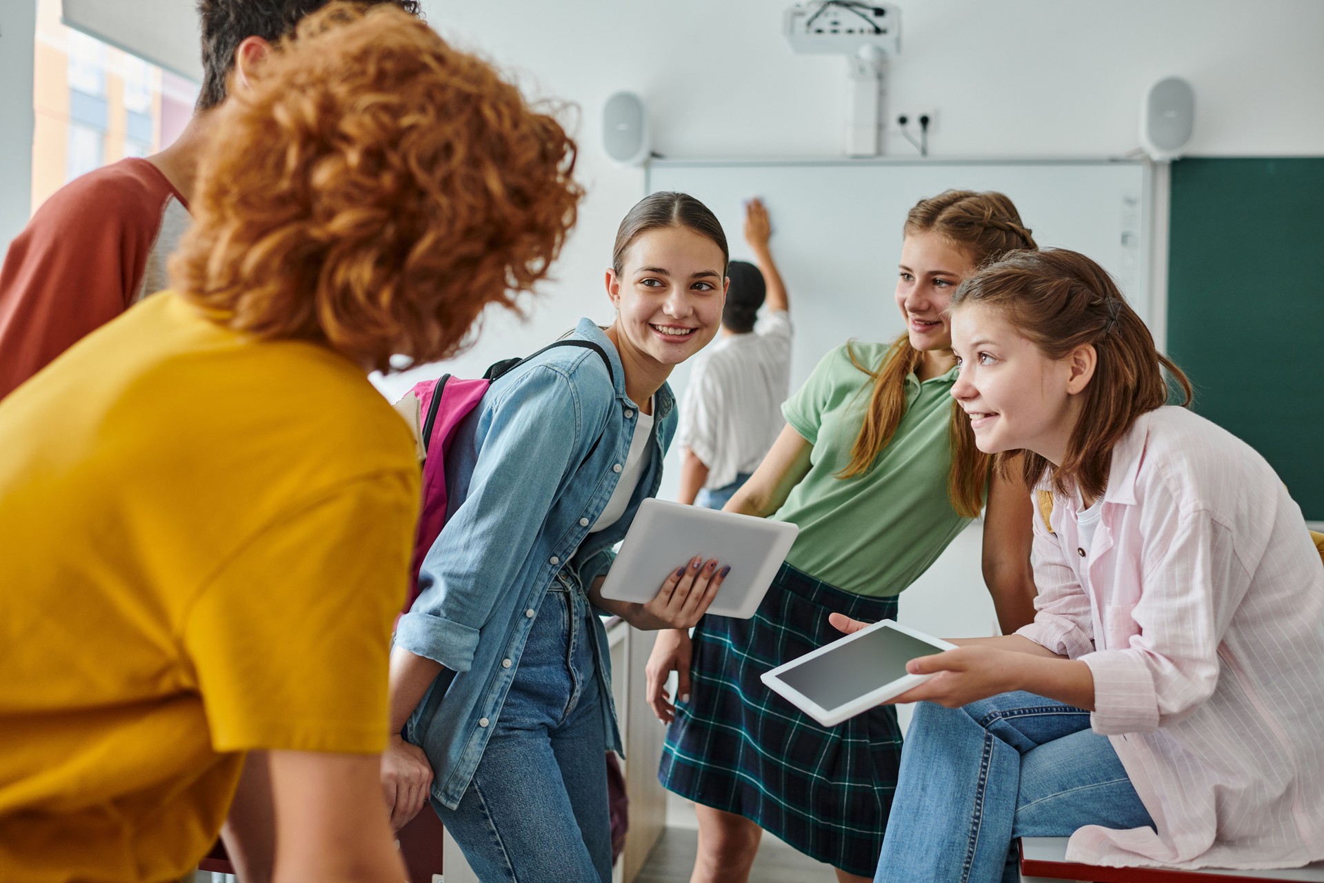 Teenage students engaging and laughing in a vibrant classroom during back-to-school season