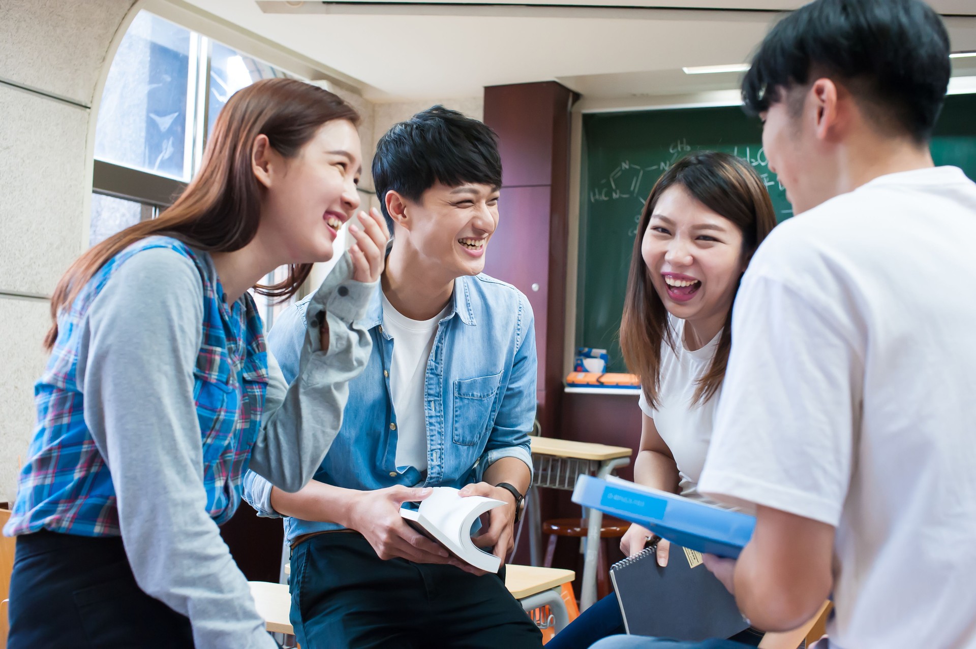 Group of young adult students having fun brainstorming in classroom
