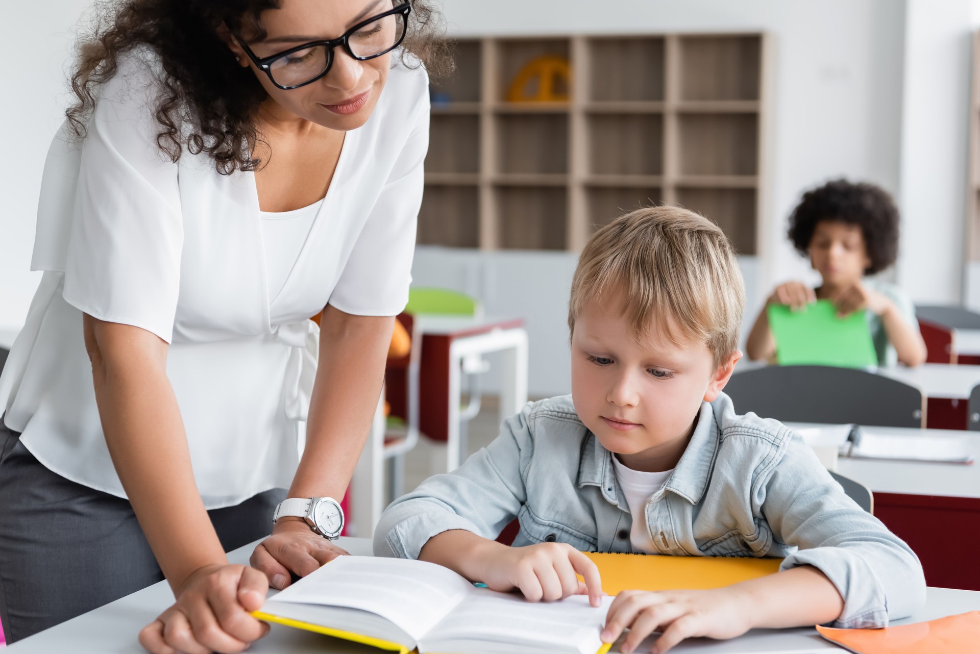 Multicultural kids engage in learning activities with caring teacher in vibrant classroom